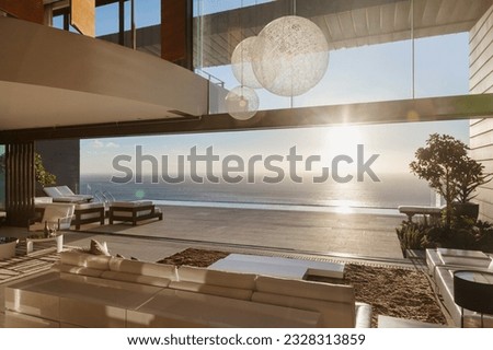 Modern living room overlooking ocean at sunset