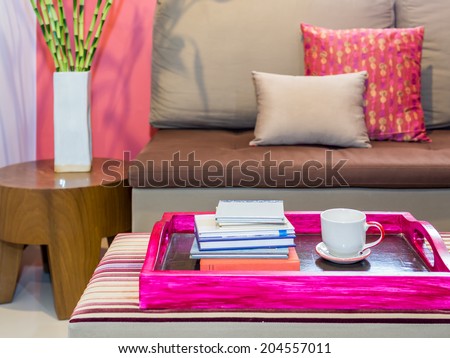Modern living room with sofa and cup of coffee  in colorful tray