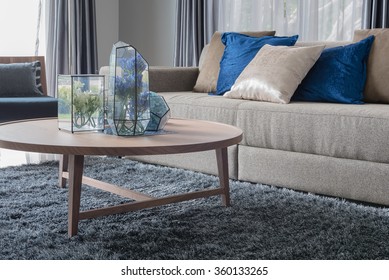 Modern Living Room With Wooden Round Table On Carpet