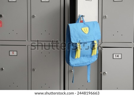 Modern locker with backpack at school, closeup