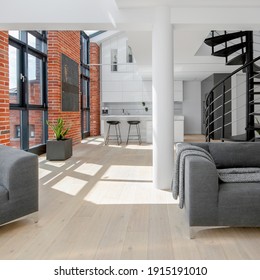 Modern Loft Apartment In White With Red Brick On The Walls, Big Windows, Black Stairs And Kitchen Open To Living Room