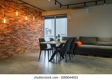 Moderne, luxuriöse, dunkelgraue und schwarze Küche mit Esstisch an der roten Backwand