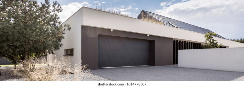 Modern Luxurious House With Huge Garage And Tree Next To Building