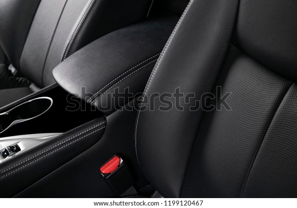 Modern luxury car black leather interior. Part\
of leather car seat details with stitching. Interior of prestige\
modern car. Comfortable perforated leather seat. Black perforated\
leather. Car detailing