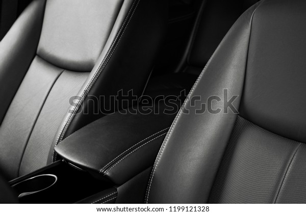 Modern luxury car black leather interior. Part\
of leather car seat details with stitching. Interior of prestige\
modern car. Comfortable perforated leather seat. Black perforated\
leather. Car detailing