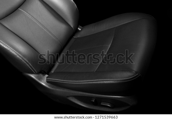 Modern luxury car black leather interior. Part\
of leather car seat detail with stitching. Interior of prestige\
modern car. Comfortable perforated leather seats. Black perforated\
leather. Car detailing
