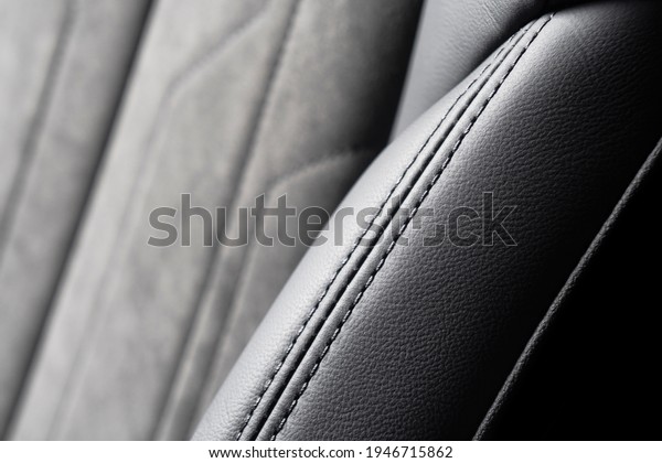Modern luxury car black leather with alcantara\
interior. Part of black leather car seat details with white\
stitching. Interior of prestige car. Perforated leather seats\
isolated. Perforated\
leather.