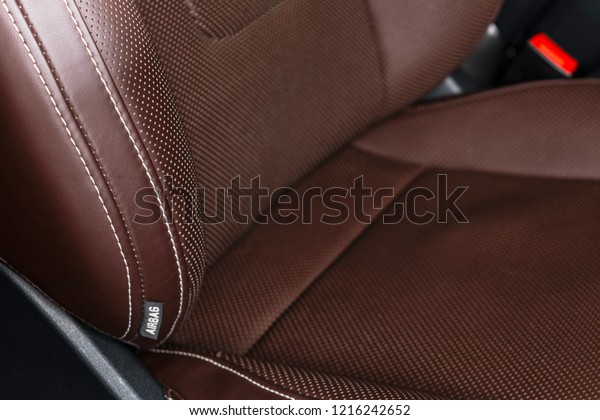 Modern luxury car brown leather interior. Part\
of leather car seat details with white stitching. Interior of\
prestige car. Comfortable perforated leather seats. Brown\
perforated leather. Car\
detailing