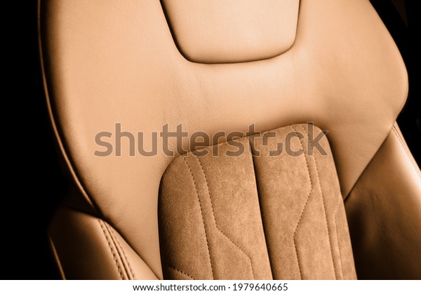 Modern luxury car brown leather with alcantara\
interior. Part of orange leather car seat details with white\
stitching. Interior of prestige car. Perforated leather seats\
isolated. Perforated\
leather.