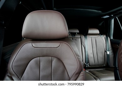 Modern Luxury Car  Brown Perforated Leather Interior. Part Of  Leather Car Headrest Seat Details. Back Seats In Background. Isolated On Black With Clipping Path