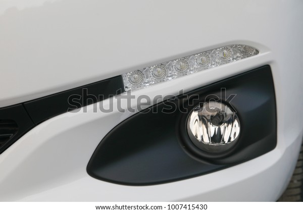 Modern and luxury car fog headlights and led\
daylight. car exterior\
detail.