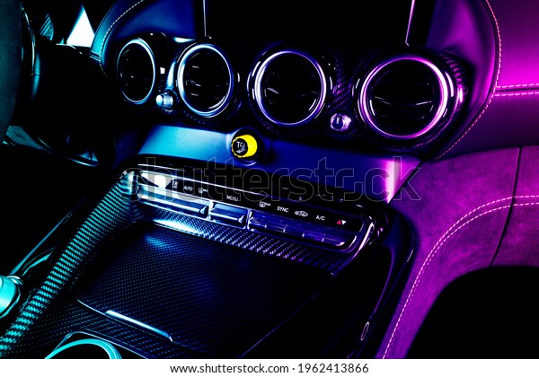 Modern\
luxury car inside in blue and pink tones. Interior of prestige\
modern car with carbon panels. Comfortable leather seats. Steering\
wheel and dashboard. automatic gear stick shift.\
