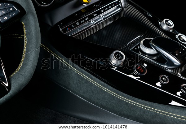 Modern Luxury car inside. Interior of prestige modern\
car. Comfortable leather seats. Black perforated leather with\
yellow stitching. Steering wheel and dashboard. automatic gear\
stick shift. 