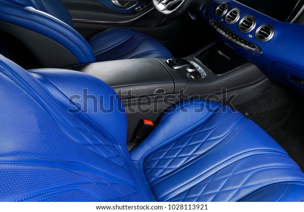Modern Luxury car inside. Interior of prestige\
modern car. Comfortable leather seats. Blue perforated leather\
cockpit. Steering wheel and dashboard. automatic gear stick shift.\
Car interior