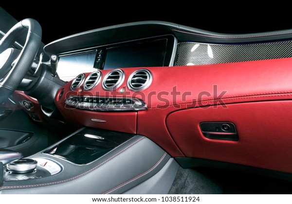 Modern Luxury car\
inside. Interior of prestige modern car. Comfortable leather seats.\
Red perforated leather cockpit. Modern car interior details.\
Dashboard and steering\
wheel