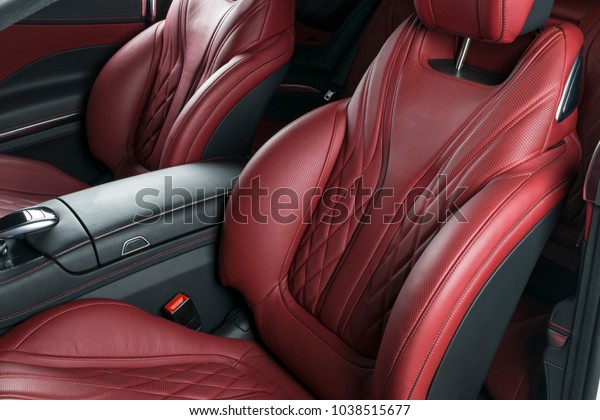 Modern\
Luxury car inside. Interior of prestige modern car. Comfortable\
leather red seats. Red perforated leather cockpit with isolated\
Black background. Modern car interior\
details