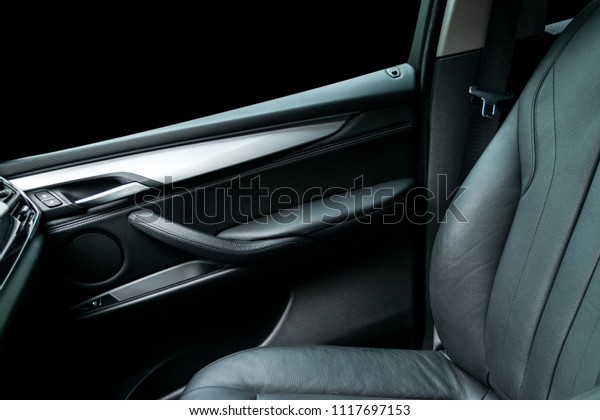Modern Luxury car inside. Interior of prestige\
modern car. Comfortable leather black seats. Black perforated\
leather cockpit with isolated Black background. Modern car interior\
details. Car detailing