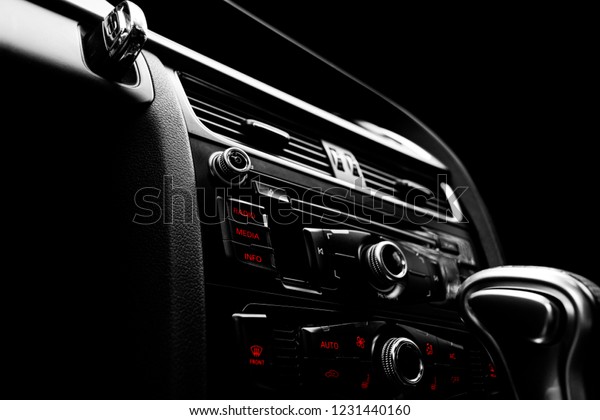 Modern Luxury car inside. Interior of prestige car.\
Black Leather. Car detailing. Dashboard. Media, climate and\
navigation control buttons. Sound system. Modern car interior\
details. Black and white