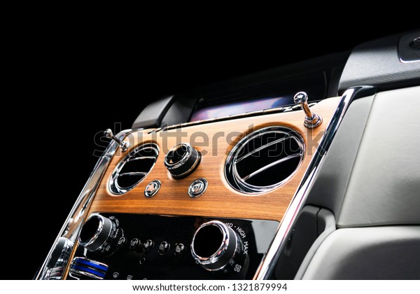 Modern Luxury car inside. Interior of a vehicle\
with natural wood panel. White Leather with stitching. Car\
detailing. Dashboard. Media, climate and navigation buttons. Car\
interior details. Car\
inside