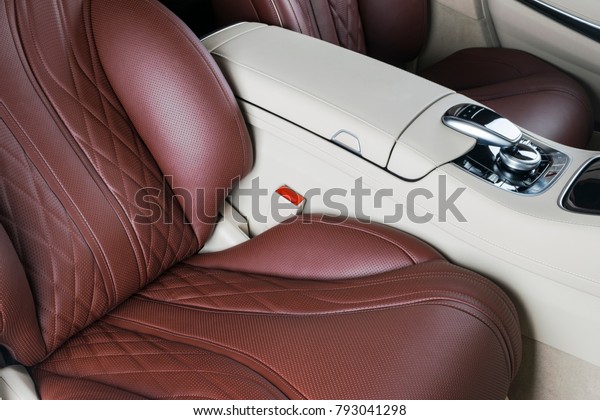 Modern Luxury car inside. Interior of prestige\
modern car. Comfortable leather seats. Red and white perforated\
leather cockpit. Modern car interior details. Media and navigation\
control buttons