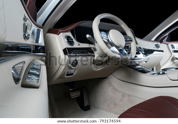 Modern Luxury car inside. Interior of prestige modern\
car. Comfortable leather seats. Red and white perforated leather\
cockpit. Steering wheel and dashboard. automatic gear stick shift.\
Car interior 