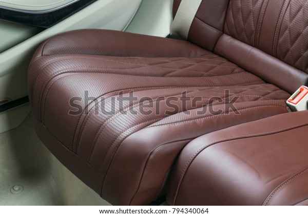 Modern Luxury car\
inside. Interior of prestige modern car. Comfortable leather seats.\
Red and white perforated leather. Back passenger seats.  Modern car\
interior details