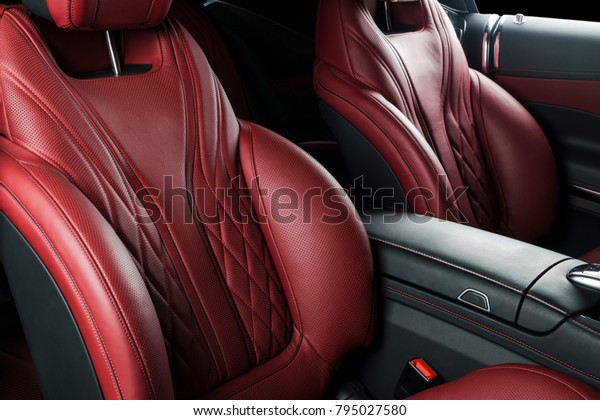 Modern Luxury car\
inside. Interior of prestige modern car. Comfortable leather seats.\
Red perforated leather cockpit with isolated Black background.\
Modern car interior\
details