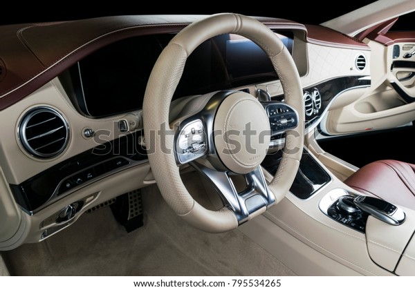 Modern Luxury car inside. Interior of prestige\
modern car. Comfortable leather seats. Red and white perforated\
leather cockpit. Steering wheel and dashboard. automatic gear stick\
shift. Car interior