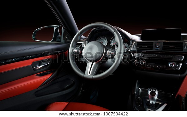 Modern luxury car\
Interior - steering wheel, shift lever and dashboard. Car interior\
luxury inside. Steering wheel, dashboard, speedometer, display. Red\
and black leather\
cockpit
