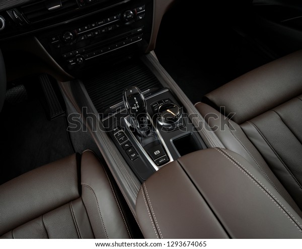 Modern luxury car Interior - steering\
wheel, shift lever and dashboard. Car interior luxury inside.\
Steering wheel, brown perforated leather\
cockpit