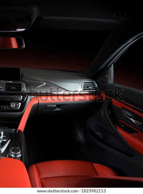 Modern
luxury car Interior - steering wheel, shift lever and dashboard.
Car interior luxury.Steering wheel, dashboard, speedometer,
display. Red and black perforated leather
cockpit
