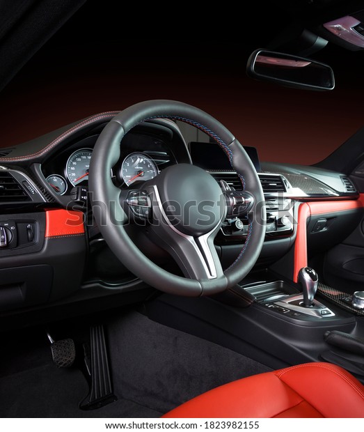 Modern luxury car\
Interior - steering wheel, shift lever and dashboard. Car interior\
luxury inside. Steering wheel, dashboard, speedometer, display. Red\
and black leather\
cockpit