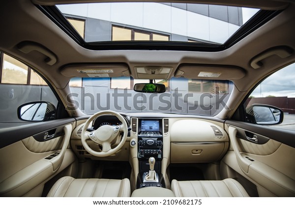 Modern luxury car Interior - steering wheel,\
shift lever and dashboard. Car interior luxury inside. Steering\
wheel, dashboard, speedometer, display.Yellow leather interior.\
White leather interior.