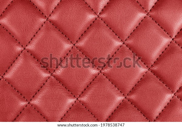 Modern luxury car red leather interior. Part of\
perforated car seat details. Red perforated leather texture\
background. Texture, artificial leather with diagonal stitching.\
Leather seats