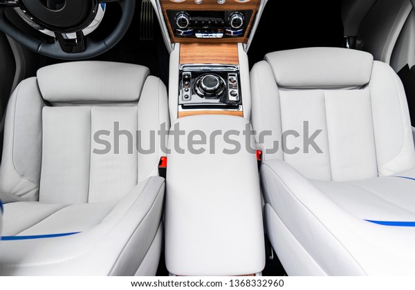 Modern\
luxury car white leather interior with natural wood panel. Part of\
leather car seat details with stitching. Interior of prestige\
modern car. White perforated leather. Car\
inside