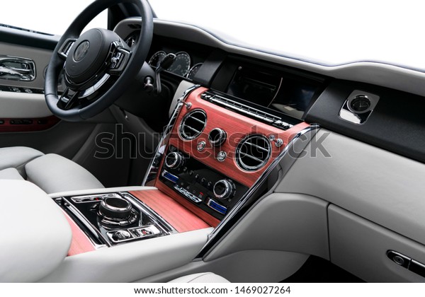 Modern luxury car white leather interior with\
natural wood panel. Part of leather seat details with stitching.\
Interior of prestige modern car. White perforated leather. Car\
detailing. Car inside