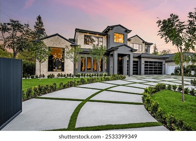 Modern luxury home exterior with a well-manicured lawn, geometric driveway, and sunset sky in the background. - Powered by Shutterstock