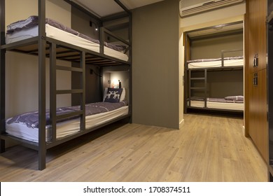 Modern, luxury, hostel, dorm, dormitory, motel room. Wooden floor room full of comfortable beds. Accomodation for students. Bedroom view from a hostel.
