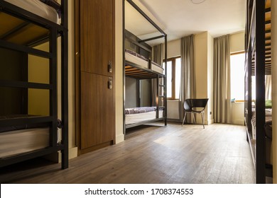 Modern, luxury, hostel, dorm, dormitory, motel room. Wooden floor room full of comfortable beds. Accomodation for students. Bedroom view from a hostel.