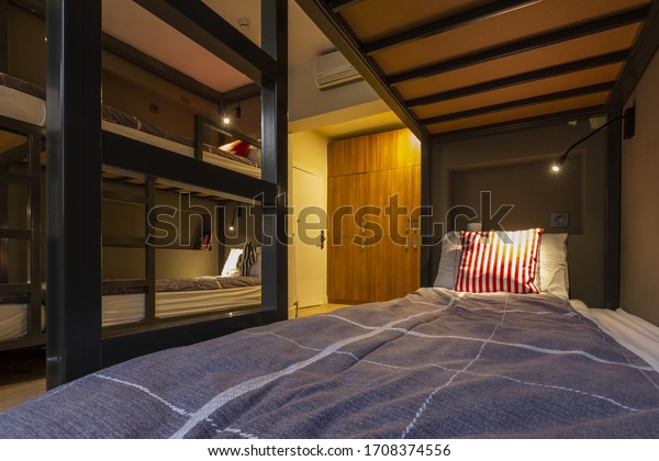 Modern, luxury, hostel, dorm, dormitory, motel\
room. Wooden floor room full of comfortable beds. Accomodation for\
students. Bedroom view from a\
hostel.