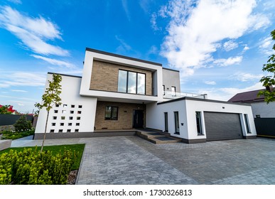 Modern Luxury House With Garage. Blue Sky Above. Nobody In The Yard. Modern Arhitecture.