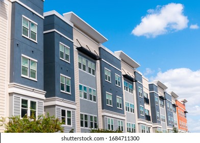 Modern luxury urban apartment building exterior with blue sky.