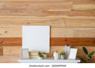 Modern Mantelpiece With Books And Frames Near Wooden Wall