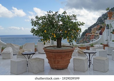 Modern Marble Terrace Overlooking Amalfi Coast And Positano Historic Town With Tables And Lemon Tree, Italy