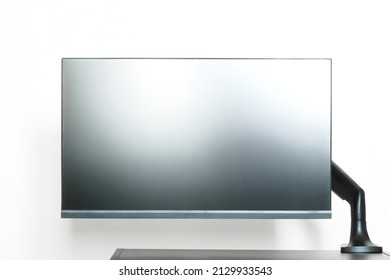 Modern Matte Computer Monitor Or TV Set Is Mounted On A Small Table With A Metal Bracket. Off-center Side Holder. The Edge Of The Table. Free Space For An Inscription. White Background