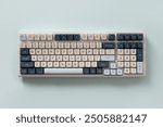 Modern mechanical keyboard isolated on blue background. Minimal style and design keyboard. Custom build keyboard. Colorful key cap. View from above.