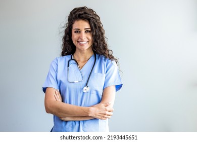 Modern Medical Education Concept. Portrait Of Smiling Female Doctor In Blue Coat Posing With Folded Arms Over Light Background. Portrait Of Female Nurse Wearing Scrubs In Hospital - Powered by Shutterstock