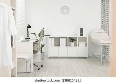 Modern medical office with doctor's workplace and examination table in clinic - Powered by Shutterstock