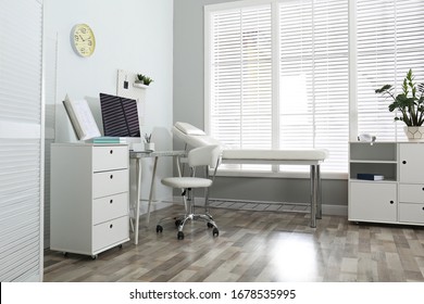 Modern medical office interior with computer and examination table