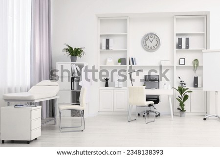 Modern medical office interior with doctor's workplace and examination table